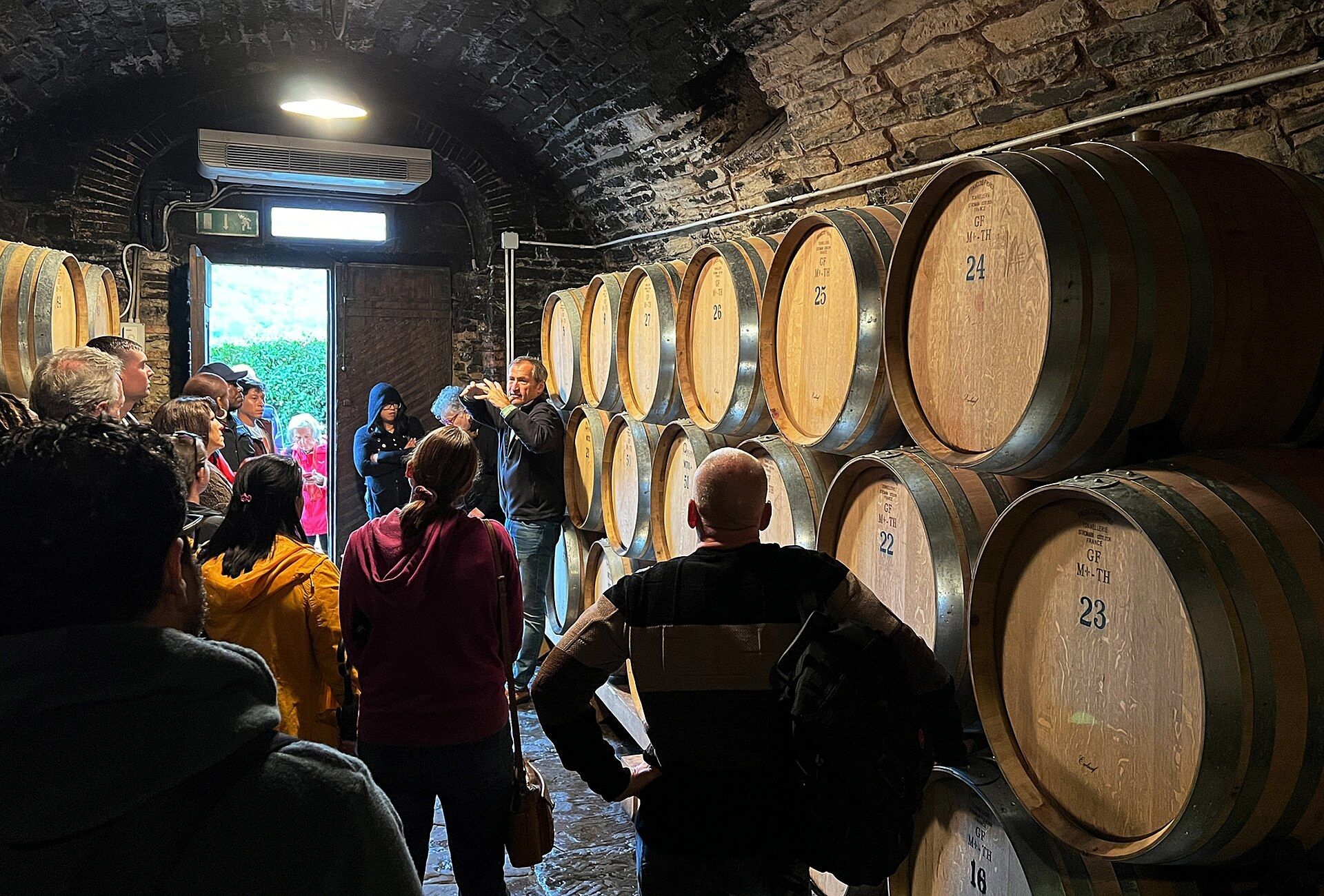 Un gruppo in visita in una cantina del Chianti tra le botti
